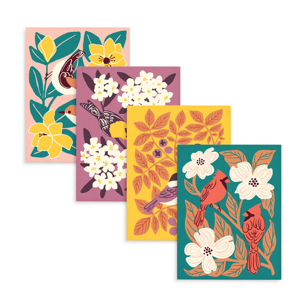 Four colorful greeting cards each with a different illustrated design of two birds (chickadees, goldfinches, cardinals, and nuthatches) surrounded by leaves and flowers.