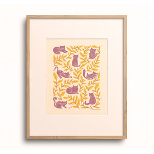 Cat Club art print displayed in a wooden frame with a white mat on a yellow backdrop.