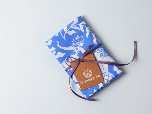 Cerulean blue and white bandana folded and tied with a Nuthatch Studio hangtag.