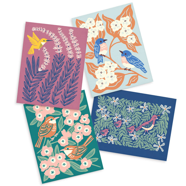 Four colorful greeting cards each with a different illustrated design of birds (hummingbird, bluebirds, wren, and quails) surrounded by leaves and flowers illustrated by Chrissie Van Hoever for Nuthatch Studio.