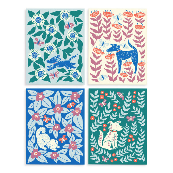 Four colorful greeting cards each with a different illustrated design of a dog surrounded by leaves and flowers illustrated by Chrissie Van Hoever.