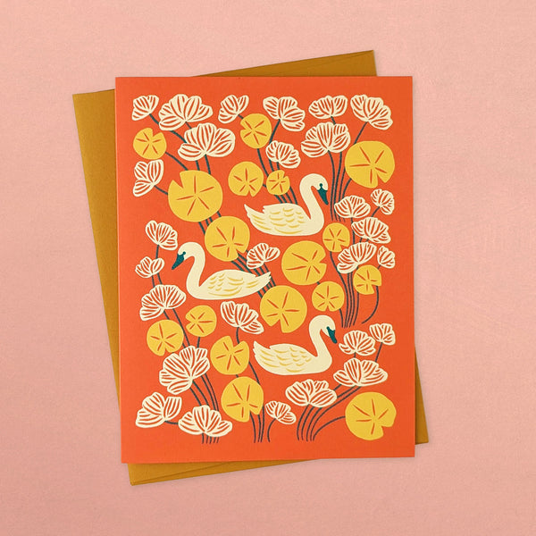 Holiday greeting card with illustration of swans in lake with lily pads