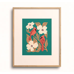 Cardinals and Dogwood art print by Chrissie Van Hoever displayed in a wooden frame.
