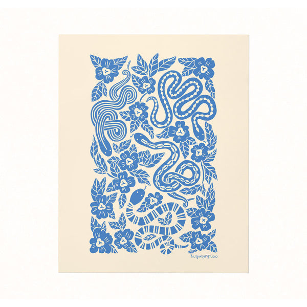 Archival print of a bold cerulean blue silhouette illustration featuring snakes slithering through a floral garden patch on an ivory backdrop.