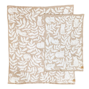 Crib and throw-size knit blankets illustrated with cats and leafy botanicals. The cats and leaves are a warm white on a creamy oatmeal color background.