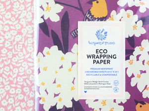 Close up view of the package label that reads “Eco Wrapping Paper. Premium Newsprint. 3 reversible sheets. Recyclable and compostable. Designed in Raleigh, NC. Milled and printed in Washington State.”
