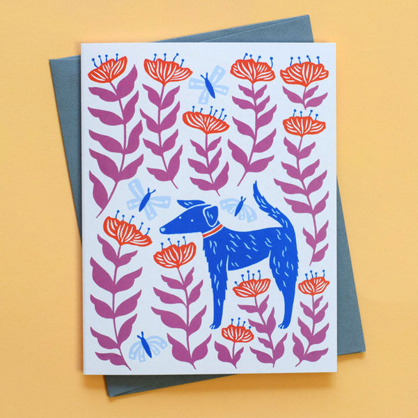 Greeting card with the illustration Petal Pup by Chrissie Van Hoever featuring a sweet pup enjoying a field of blooms and butterflies.