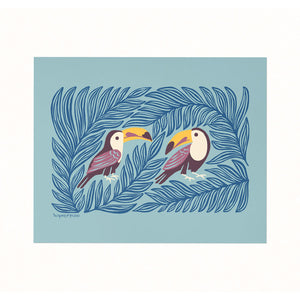 Archival print of an illustration featuring a pair of colorful toucans sheltered in the leaves on a soft blue background.
